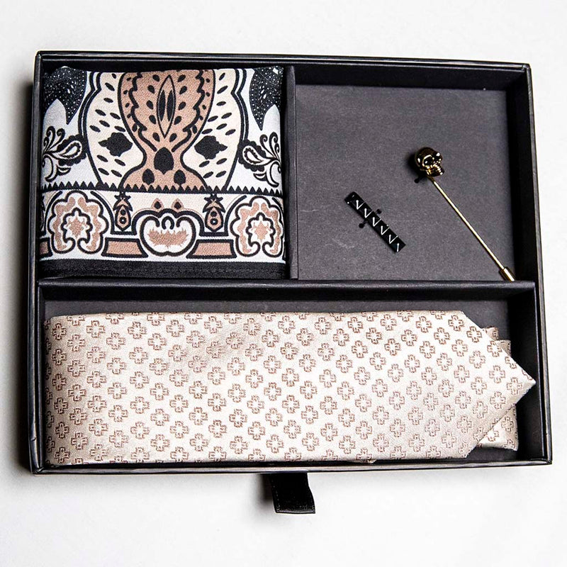 top view of pharaoh set of men's suit accessories in a gift box - he silk tie’s simple pattern resembling hieroglyphics is a great contrast to the ornamental, paisley silk pocket square, and the black tie bar resembling a sarcophagus is the perfect complement to the gold skull lapel pin of the pharaoh himself